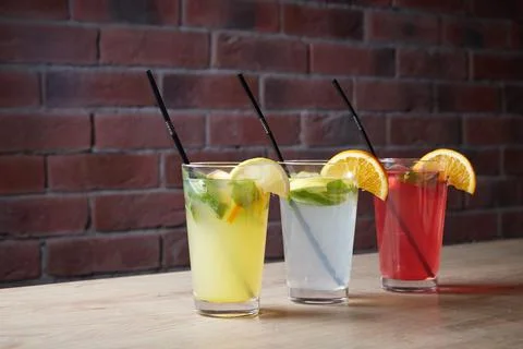 On the table, soft drinks, various cocktails, a glass with a straw and a slice Stock Photos