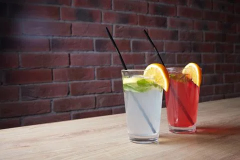 On the table, soft drinks, various cocktails, a glass with a straw and a slice Stock Photos