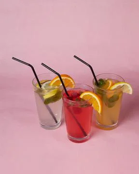 On the table, soft drinks, various cocktails, a glass with a straw and a slice Stock Photos