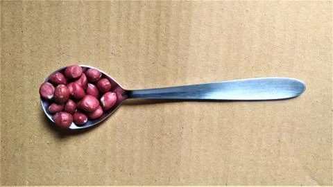 A table spoon with almonds with space for text in brown background 写真素材