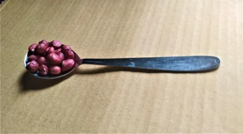 A table spoon with almonds with space for text in brown background 写真素材