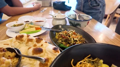 Table Spread of Traditional Burmese Dishes in Restaurant Stock Footage 345477198