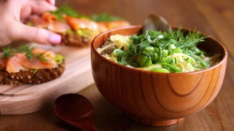 On table steaming hot soup with noodles and bruschetta topped with fish for Stock Footage 266693155