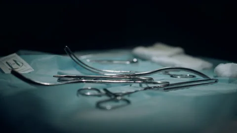 Table with surgical instruments in dark sterile operating room side view closeup Stock Footage 177986486