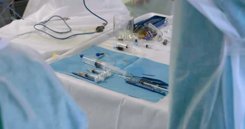 Table with surgical instruments during surgery in operating room. Nurse hands Stock Footage 154257213