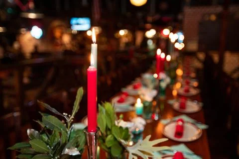 Table with tableware at the bar is beautifully set with red candles Stock Photos