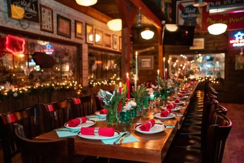 Table with tableware at the bar is beautifully set with red candles. Stock Photos