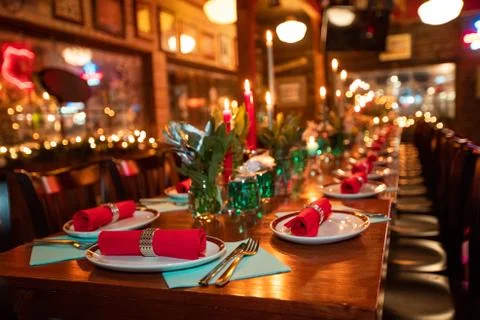 Table with tableware at the bar is beautifully set with red candles. Stock Photos
