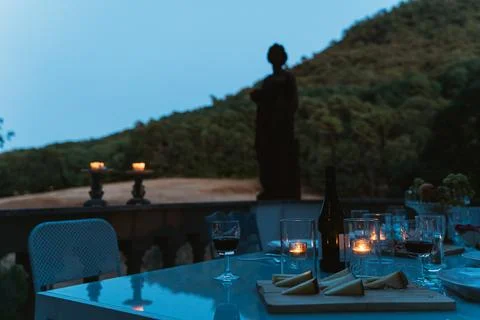 Table on the terrace set for an aperitif lit by burning candles 库存照片