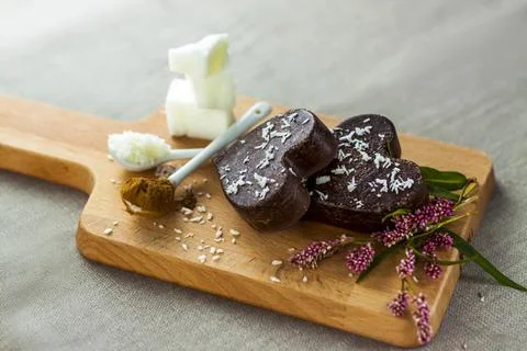 On the table there are handmade chocolates made of coconut oil, coconut chips Stock Photos