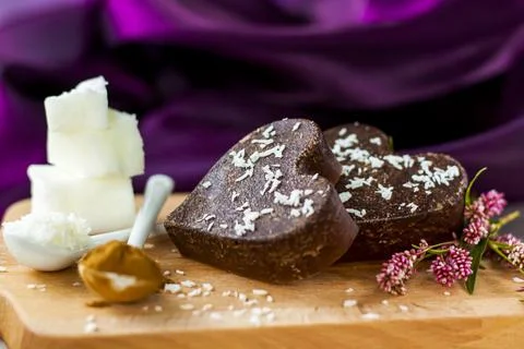 On the table there are handmade chocolates made of coconut oil, coconut chips Stock Photos