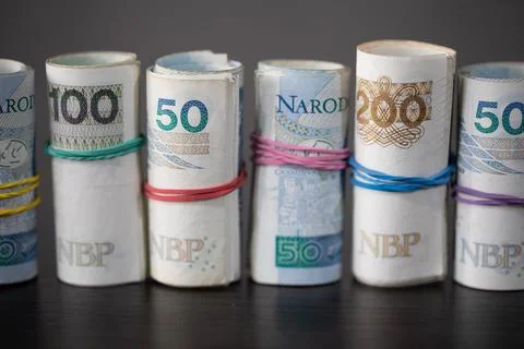 On the table there are Polish banknotes rolled up in a row and tied with a Foto stock