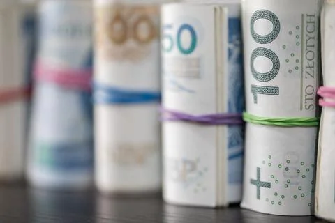 On the table there are Polish banknotes rolled up in a row and tied with a Stock-Fotos