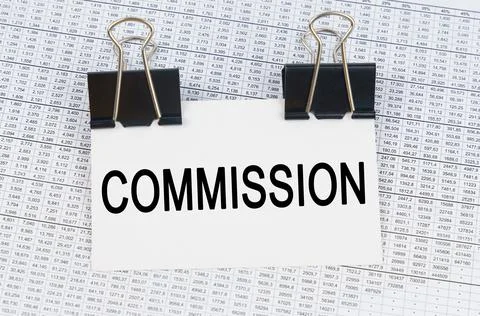 On the table there are reports and a business card with the inscription - COM Stock Photos