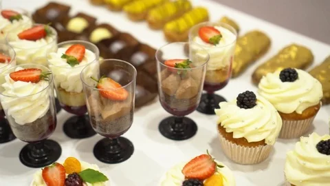 On a table there are small desserts. A buffet reception at a conference. It is a Stock Footage 82083518