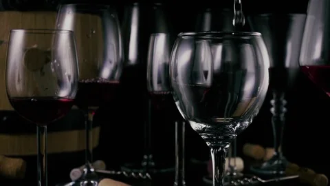 On the table there are wine-filled glasses, an empty glass of wine is pouring Stock Footage 75153850
