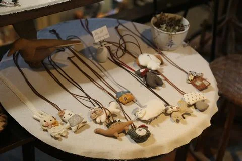 On the table, there is an array of handmade necklaces with various cute ani.. Foto stock