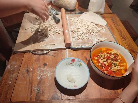 On the table, there is an empty white bowl with noodles in it and two bowls.. Stock Photos