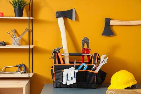 Table with tool box, hardhat and axe in carpenters workshop Stock Photos