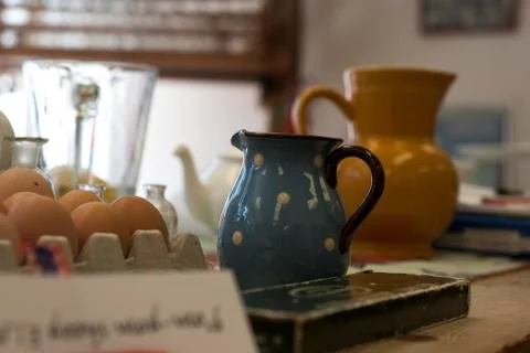A table top of colourful clutter of jugs, teapots, bit and bobs Stock Photos