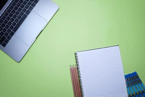 Table top flat lay of office. Top view laptop, Spiral notebook and pencils on Stock Photos