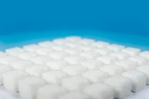 Table top shot Group of Sugar cubes vary position on light blue background Stock Photos