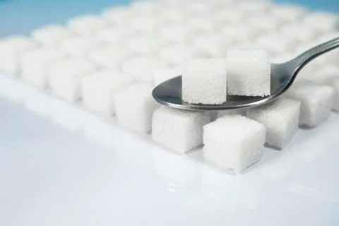 Table top shot Group of Sugar cubes vary position on light blue background Stock Photos