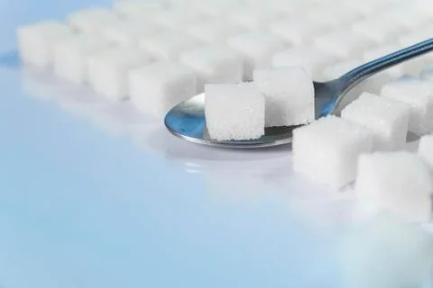 Table top shot Group of Sugar cubes vary position on light blue background Stock Photos