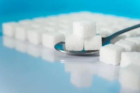 Table top shot Group of Sugar cubes vary position on light blue background Stock Photos