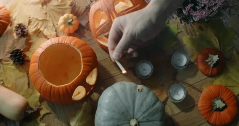 Table top video of fire up the candles near the halloween pumpkin face Stock Footage 165409095