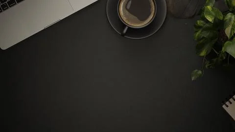 Table top view of black textured surface with coffee cup, laptop, plant and.. Stock Illustration