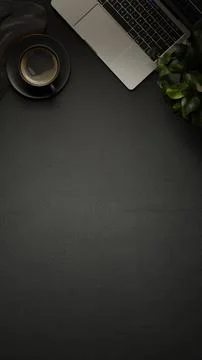 Table top view of a coffee cup and laptop on dark black surface with green .. Stock Illustration