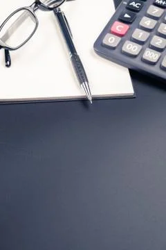Table top view of pen, notebook and calculator on office desk Stock Photos