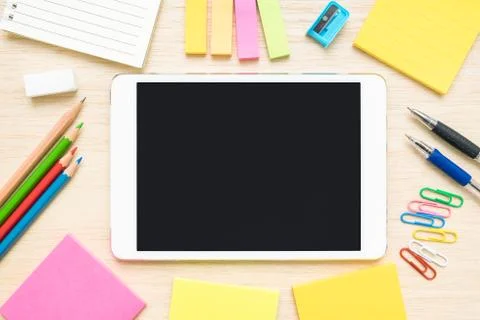 Table top view of stationery items and tablet on wooden desk Stock Photos