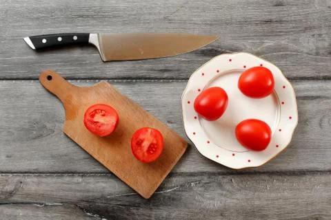 Table top view on three tomatoes on white porcelain plate with red dots, cutt Stock Photos