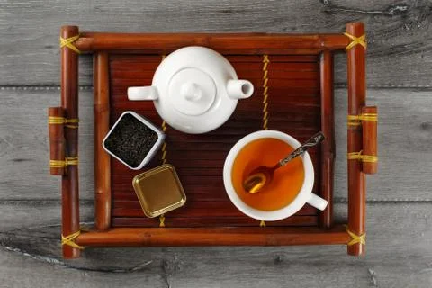 Table top view on white ceramic teapot, cup of hot black tea with silver spoo Stock Photos