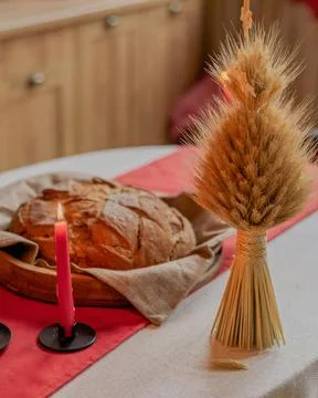 Table topped with a loaf of bread and a candle Stock Photos