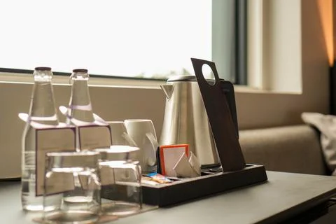 Table With Tray of kettle cups and Glasses with Bottle of water in black Hotel R Foto stock