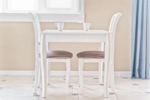 Table, two chairs and two cups of coffee in a bright, clear room Foto stock
