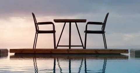 Table for two at high end restaurant with pool during sunset. Video stock 156415307