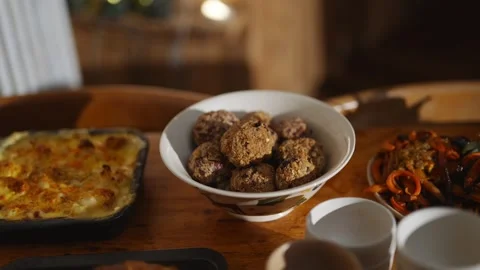 A table with a variety of food items, including a bowl of meatballs and a pie Stock Footage 295370689
