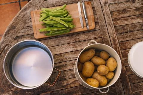 Table where beans and potatoes are being prepared. Stock Photos