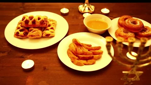 On the table on which are donuts fried in oil, cakes, honey and chips are men Stock Footage 82097015
