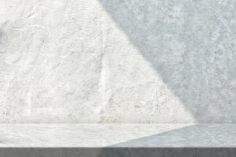 Table with White Stucco Wall Texture Background with Light Beam and Shadow Foto stock