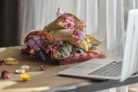 Table by the window and bouquets of dried preserved flowers. 스톡 사진
