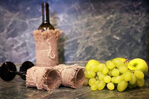 Table with wine bottle grape various vintage elements on old worn backgrou... Stock Photos