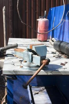 Table, workbench with white top and old rusty vise. Stock Photos