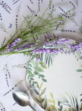 Tablecloth with lavender print and serving plate with napkin Stock Photos