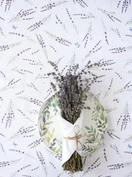 Tablecloth with lavender print and serving plate with napkin Stock Photos