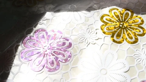 Tablecloth with painted in a flower lies on the table in sunlight glistens iride Stock Footage 106935264